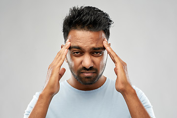 Image showing unhappy indian man suffering from headache