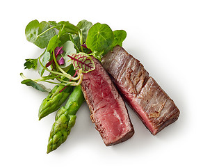 Image showing beef wagyu steak meat with herbs and asparagus isolated on wight