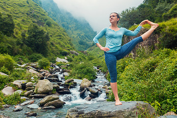 Image showing Woman doing Yoga asana outdoors at waterfall