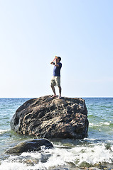 Image showing Man stranded on a rock in ocean