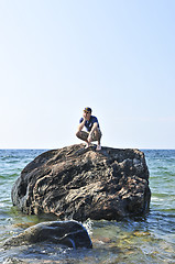 Image showing Man stranded on a rock in ocean