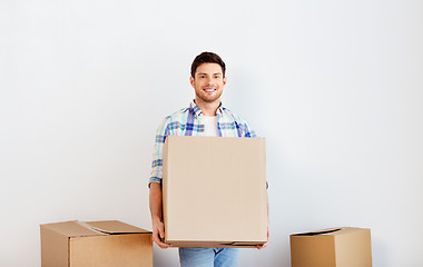 Image showing happy man with cardboard box moving to new home