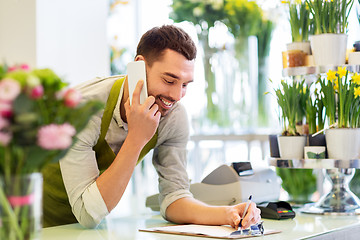 Image showing florist man calling on smartphone at flower shop