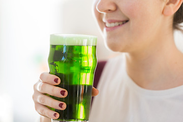 Image showing close up of woman with green beer in glass