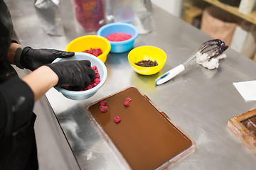 Image showing confectioner makes chocolate dessert at sweet-shop