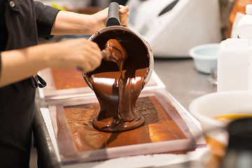 Image showing confectioner makes chocolate dessert at sweet-shop