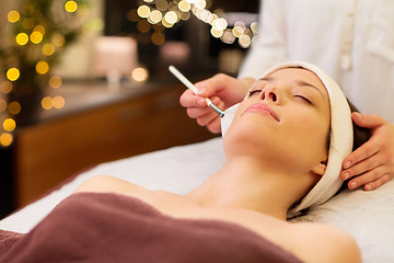 Image showing beautician applying facial mask to woman at spa