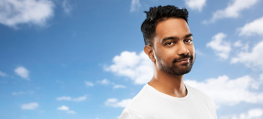 Image showing smiling young indian man over blue sky background