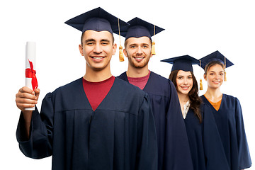 Image showing graduates in mortar boards with diploma