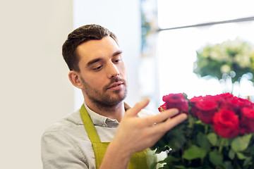 Image showing florist or seller setting red roses at flower shop