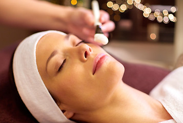 Image showing beautician applying facial mask to woman at spa