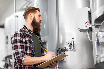 Image showing man with clipboard at craft brewery or beer plant