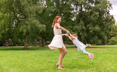 Image showing happy mother playing with baby girl at summer park