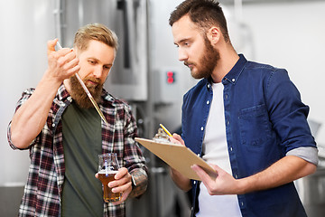 Image showing men with pipette testing craft beer at brewery