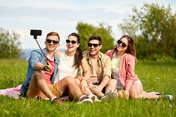 Image showing friends taking picture by selfie stick in summer