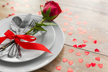 Image showing close up of red rose flower on set of dishes