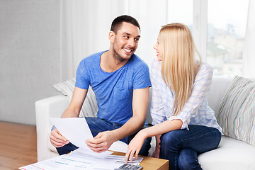Image showing couple with paper bills and calculator at home