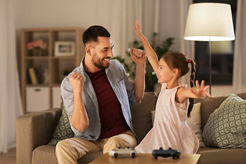 Image showing father and daughter playing video game at home