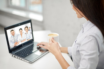 Image showing woman drinking coffee and having video conference