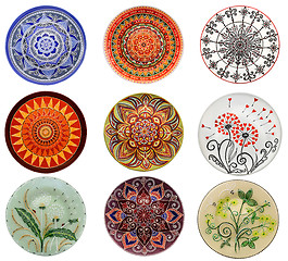 Image showing Set of decorative ceramic dishes hand-painted with acrylic paints floral pattern isolated on white background