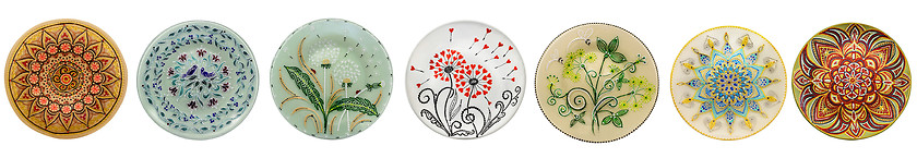 Image showing Set of decorative ceramic dishes hand-painted with acrylic paints floral pattern isolated on white background