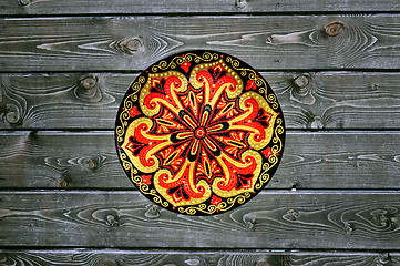 Image showing Decorative ceramic plate, hand painted with acrylic paints on a wooden background. Closeup with place for text.