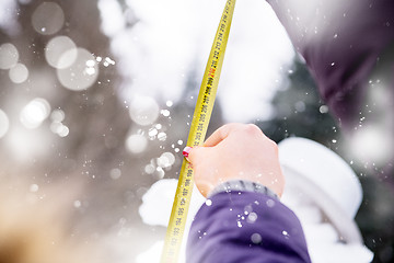 Image showing young people measuring the height of finished snowman