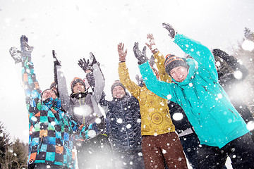 Image showing group of young people throwing snow in the air