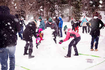 Image showing group of young people making a snowman