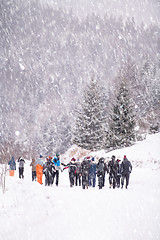 Image showing group of young people walking through beautiful winter landscape