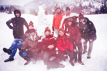 Image showing group portait of young people posing with snowman