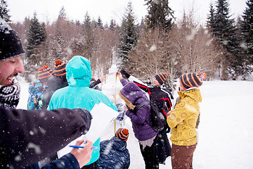 Image showing young people measuring the height of finished snowman