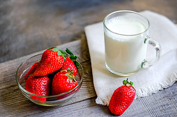 Image showing Fresh strawberries and milkshake on a wooden on wooden boards