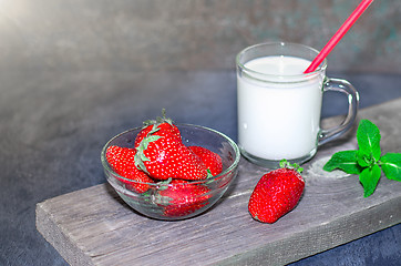 Image showing Fresh strawberries and milkshake on a wooden on wooden boards