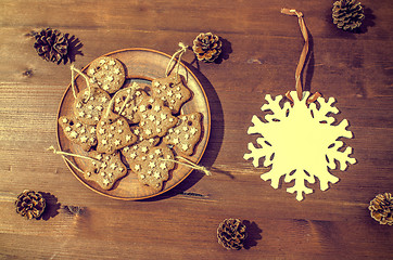 Image showing Christmas theme with cookies, spruce cones on a dark background. Flat lay.