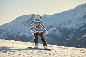 Image showing Female snowboarder in sun flare