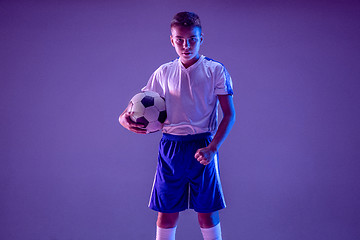 Image showing Young boy as a soccer or football player on dark studio background