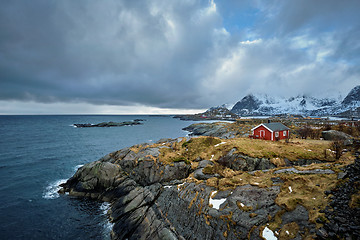 Image showing Clif with traditional red rorbu house on Lofoten Islands, Norway