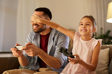 Image showing father and daughter playing video game at home