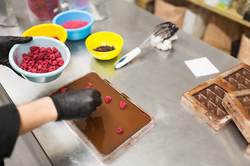 Image showing confectioner makes chocolate dessert at sweet-shop