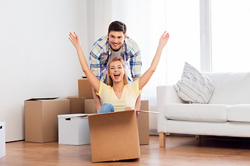 Image showing happy couple having fun with boxes at new home