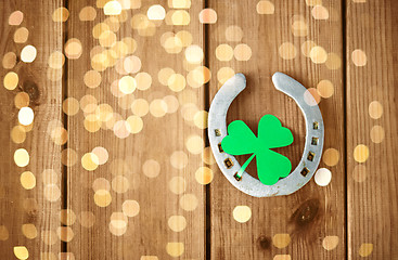 Image showing horseshoe with shamrock on wooden background