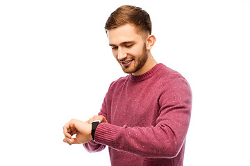 Image showing smiling young man checking time on wristwatch