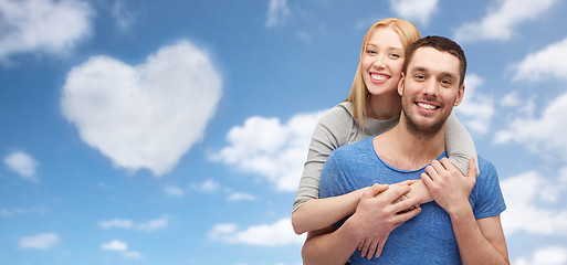 Image showing couple hugging over sky and heart shaped cloud