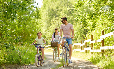 Image showing happy family riding bicycles in summer park