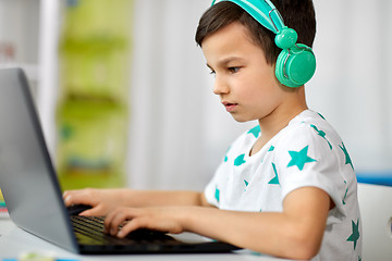 Image showing boy in headphones playing video game on laptop