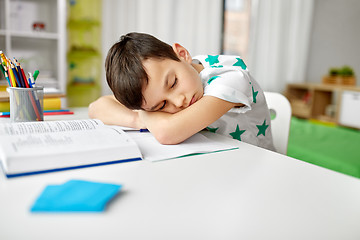 Image showing tired student boy sleeping on table at home