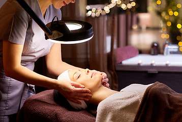 Image showing beautician doing face massage to woman at spa