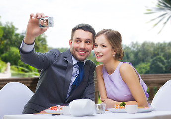 Image showing happy couple taking selfie at sushi restaurant