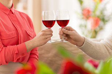 Image showing hands of couple with red wine glasses toasting 